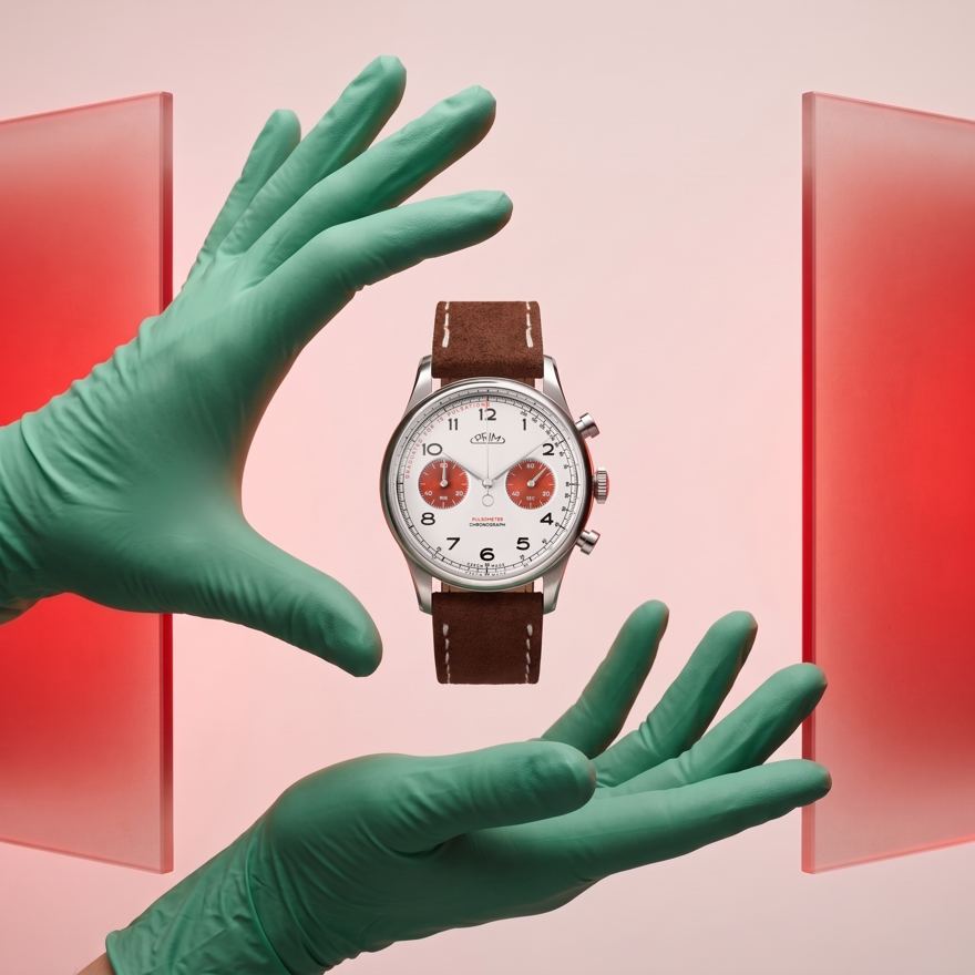 Ruce v zelených rukavicích držící chronograf